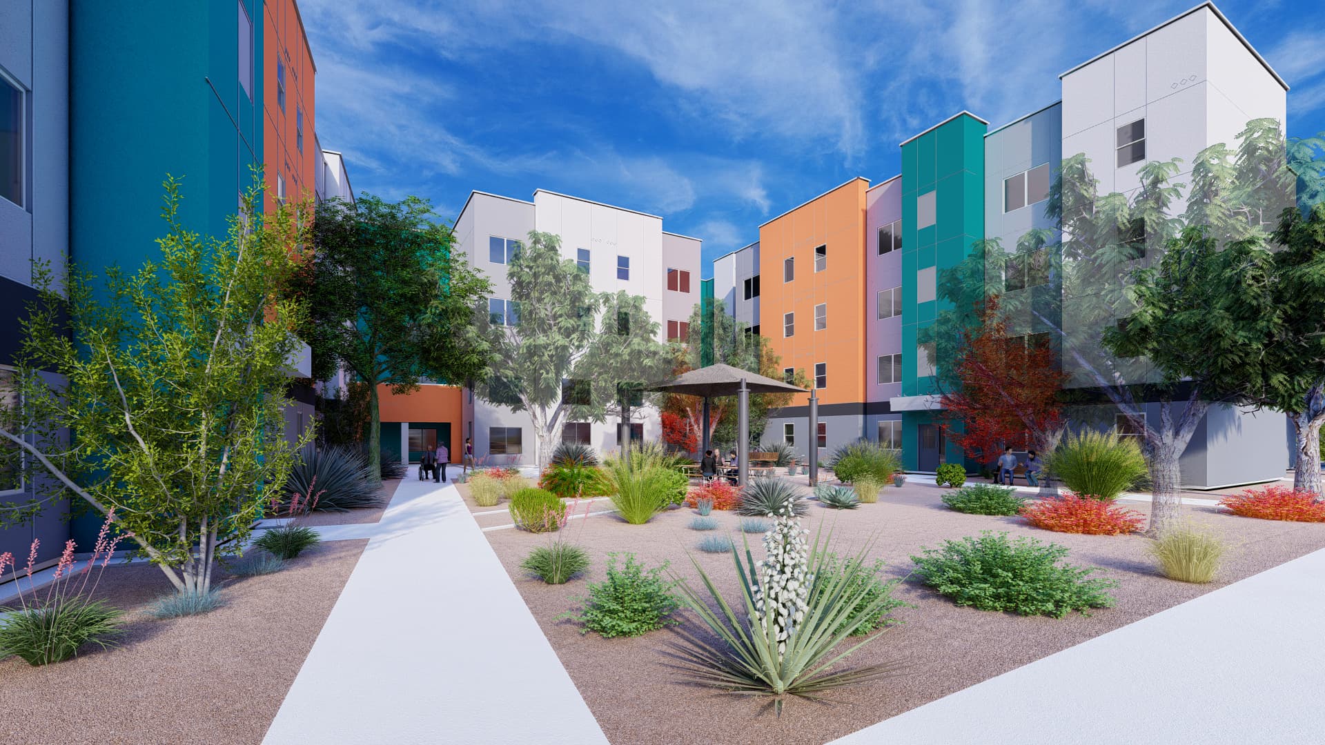 Colorful four story apartment building with courtyard, trees, and desert landscaping.